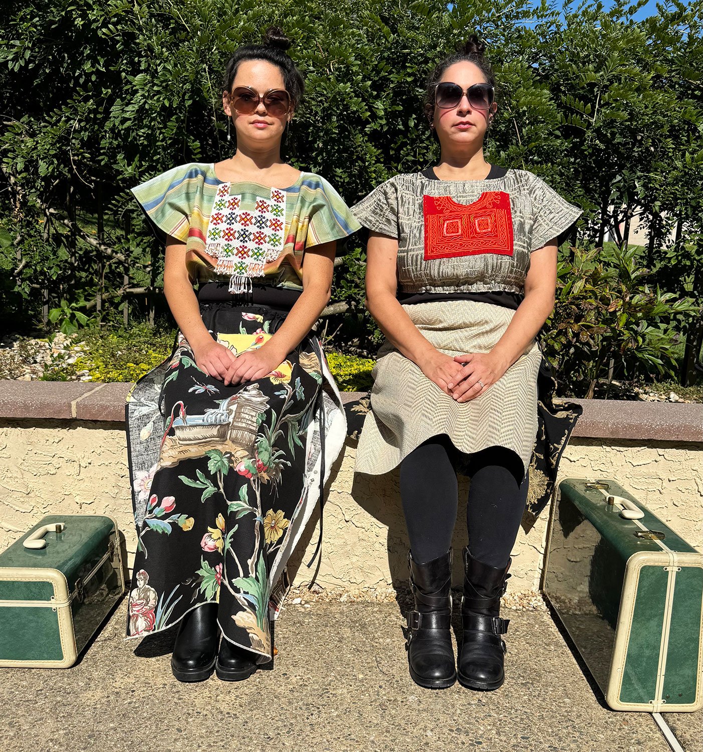 Frida Capelet with beaded antique tribal panel and Piper skirts/dresses/capes on models sitting with suitcases