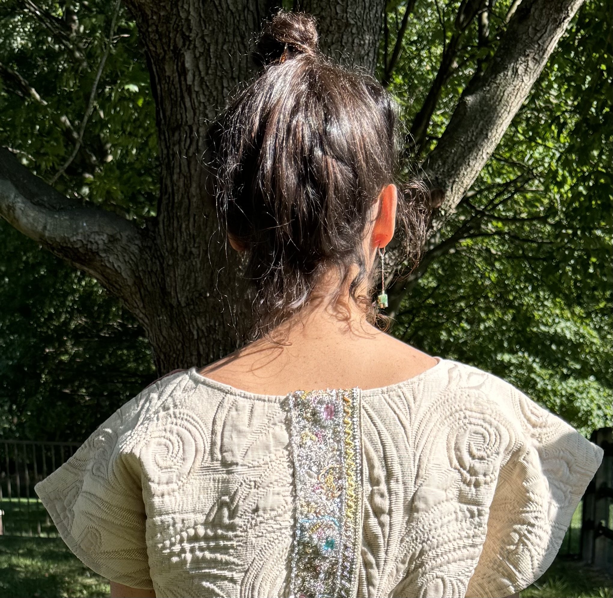 Shelby emerald earrings on model back view in Frida Shacket.