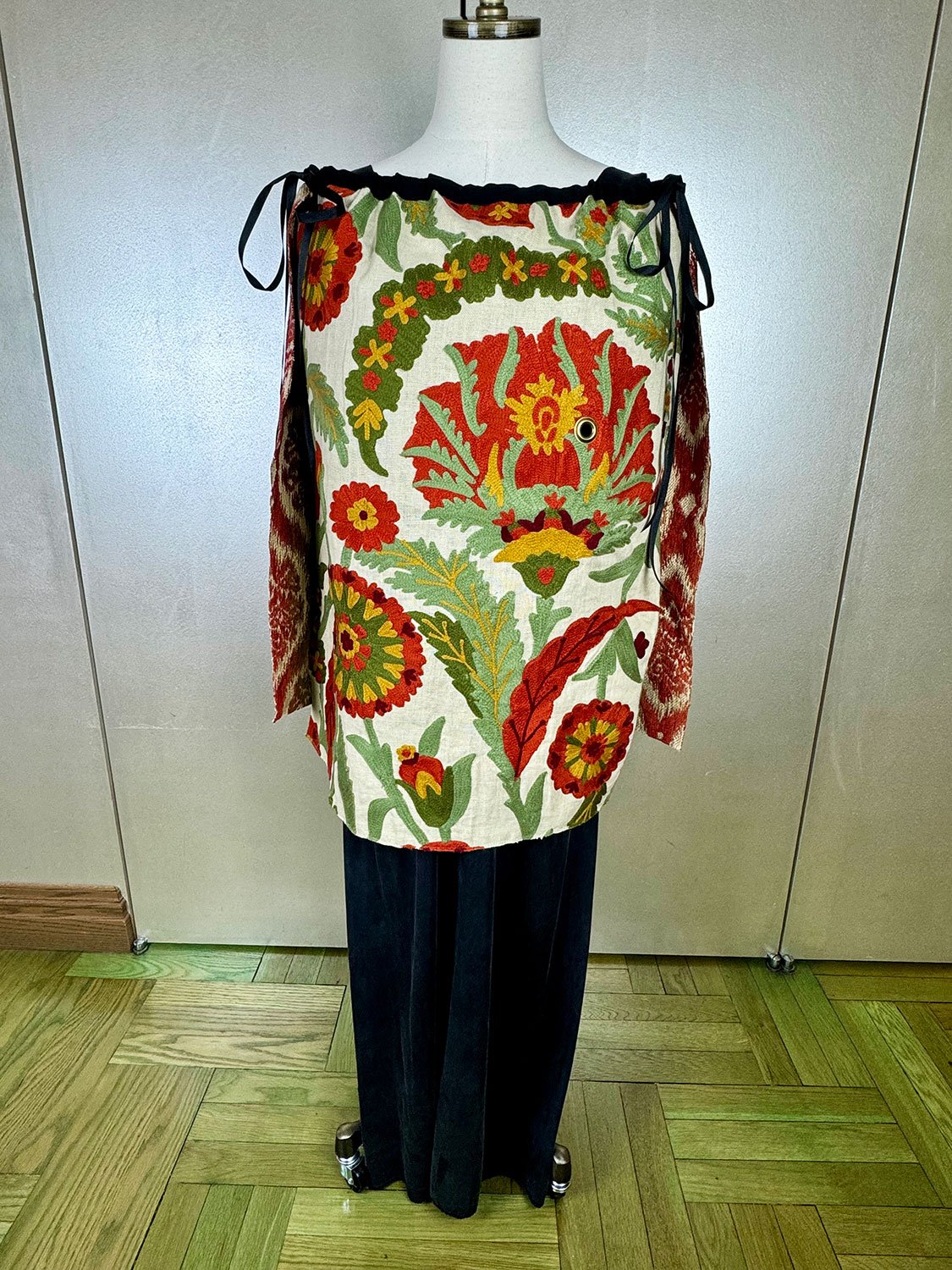 Piper overskirt on mannequin shown as cape front view with ribbon bow accents
