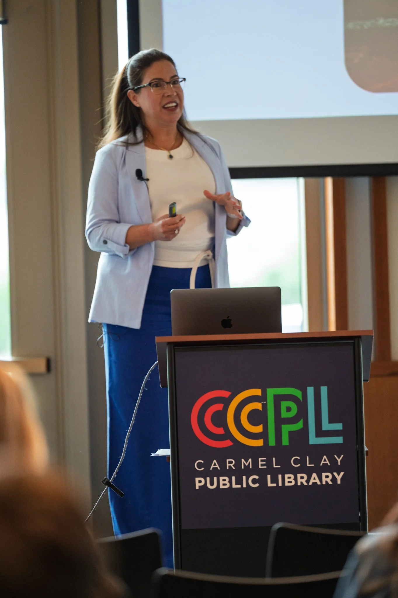 Toyi Rodriguez stands behind a podium at the Carmel Clay Public LIbrary and presents her book, “Global Citizen.”
