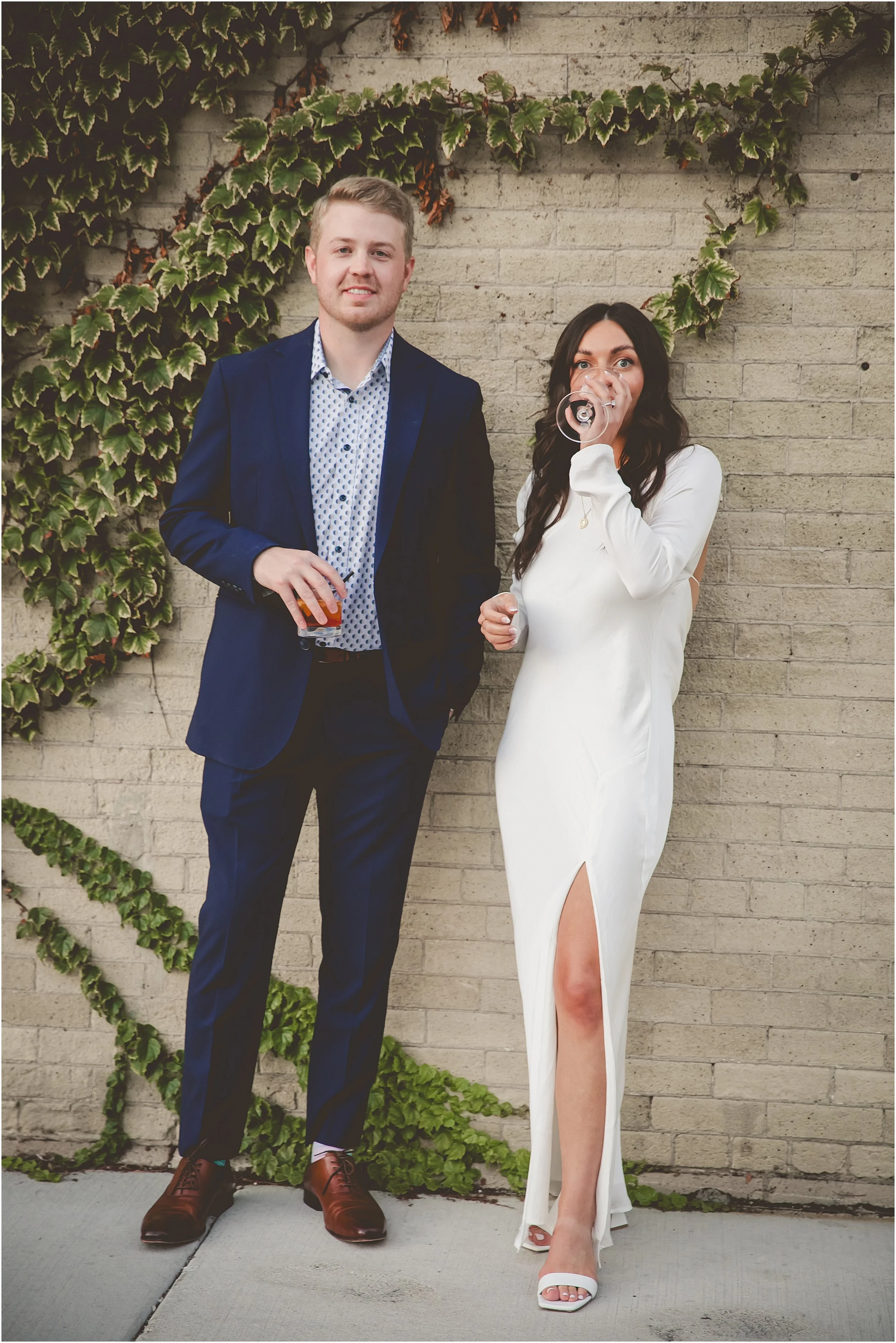 editorial-groom-bride-drinking-wine-brick-wall