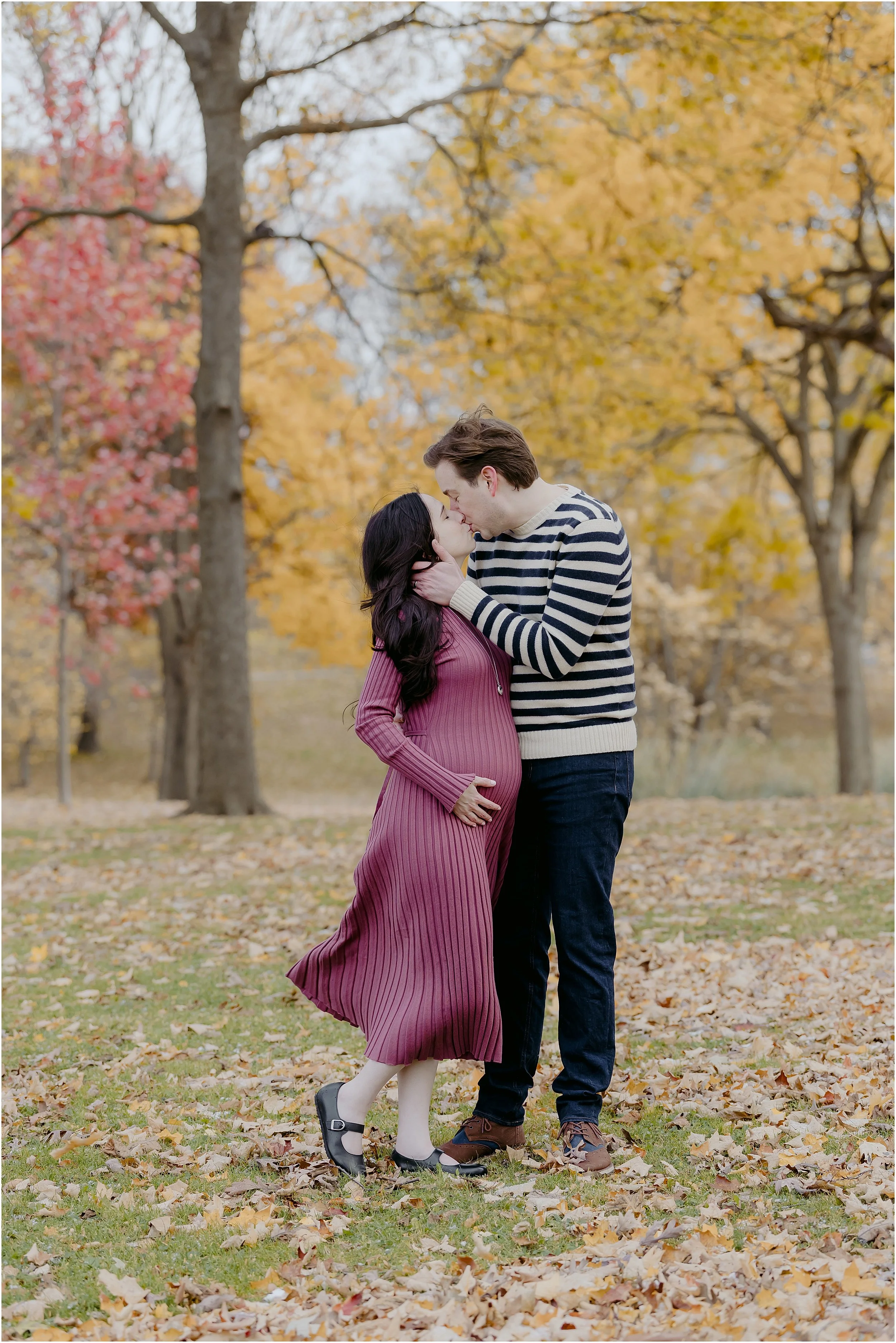 maternity-fall-photos-man-kissing-pregnant-woman-yellow-red-leaves.JPG