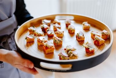 waiter holding a tray of canapes at suffolk wedding venue butley priory