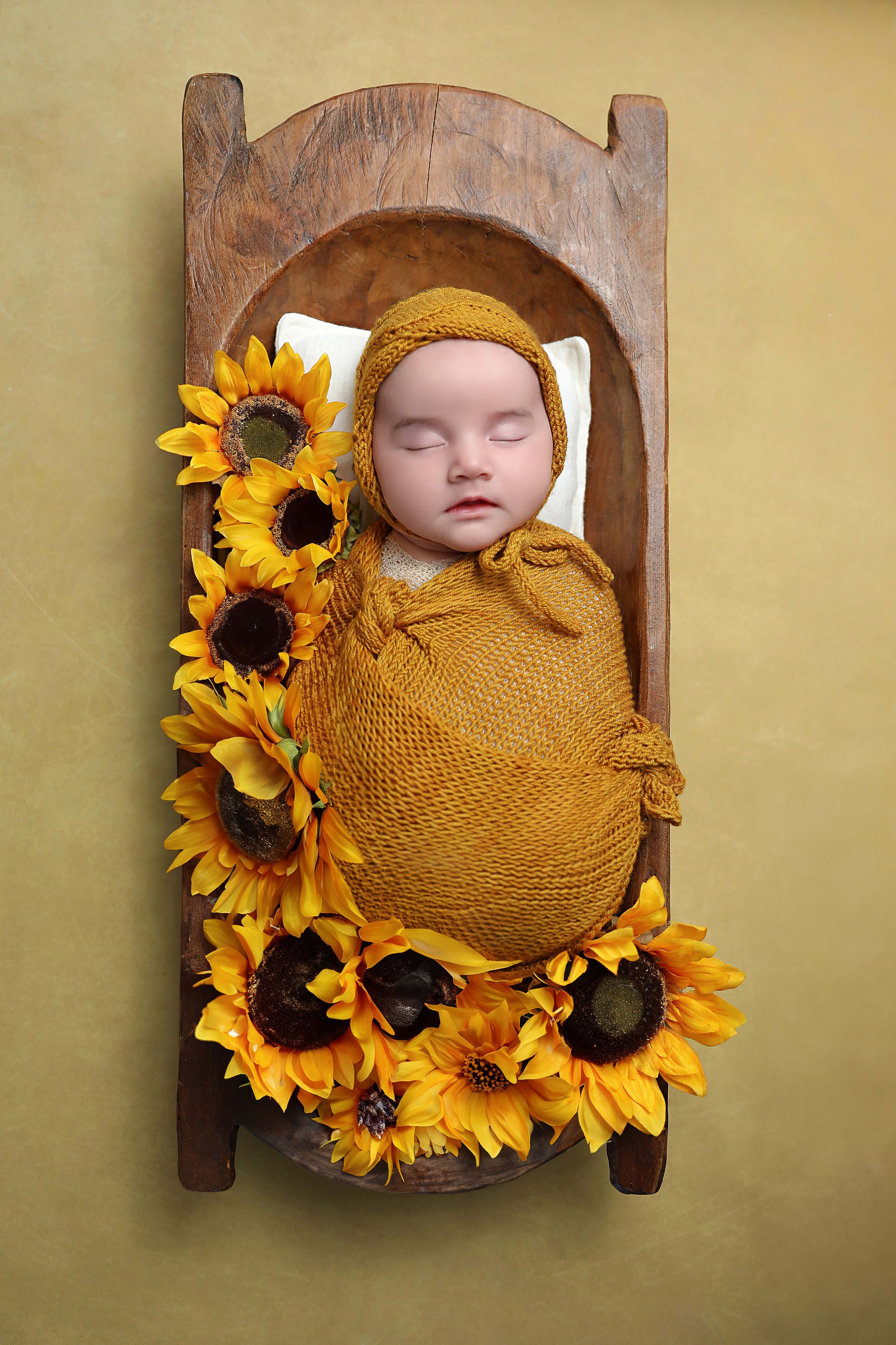 A wrapped newborn in a trough bowl in Palm Desert Photography Studio