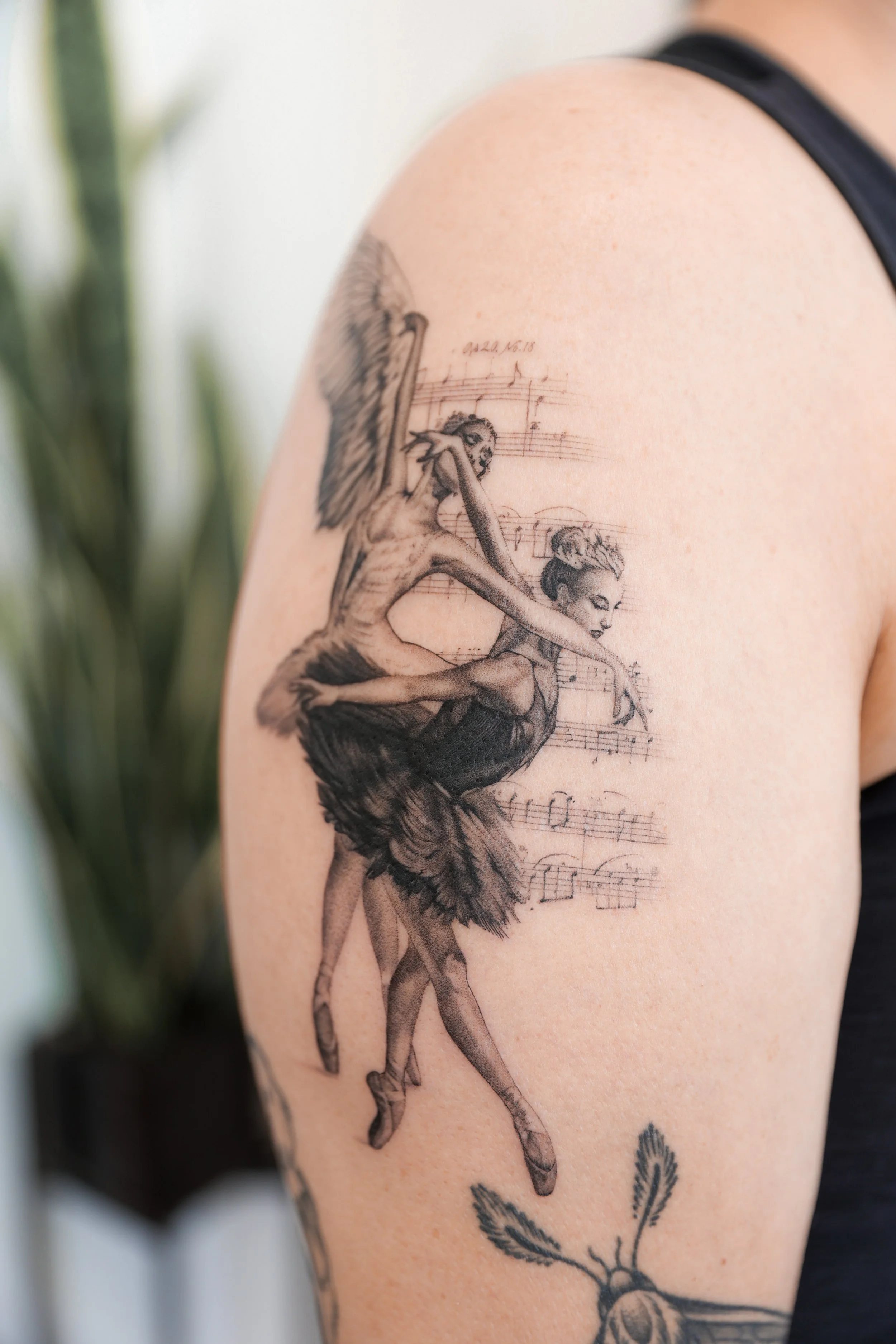 Tattoo of a ballerina woman singing with a mythical creature, surrounded by musical notes.