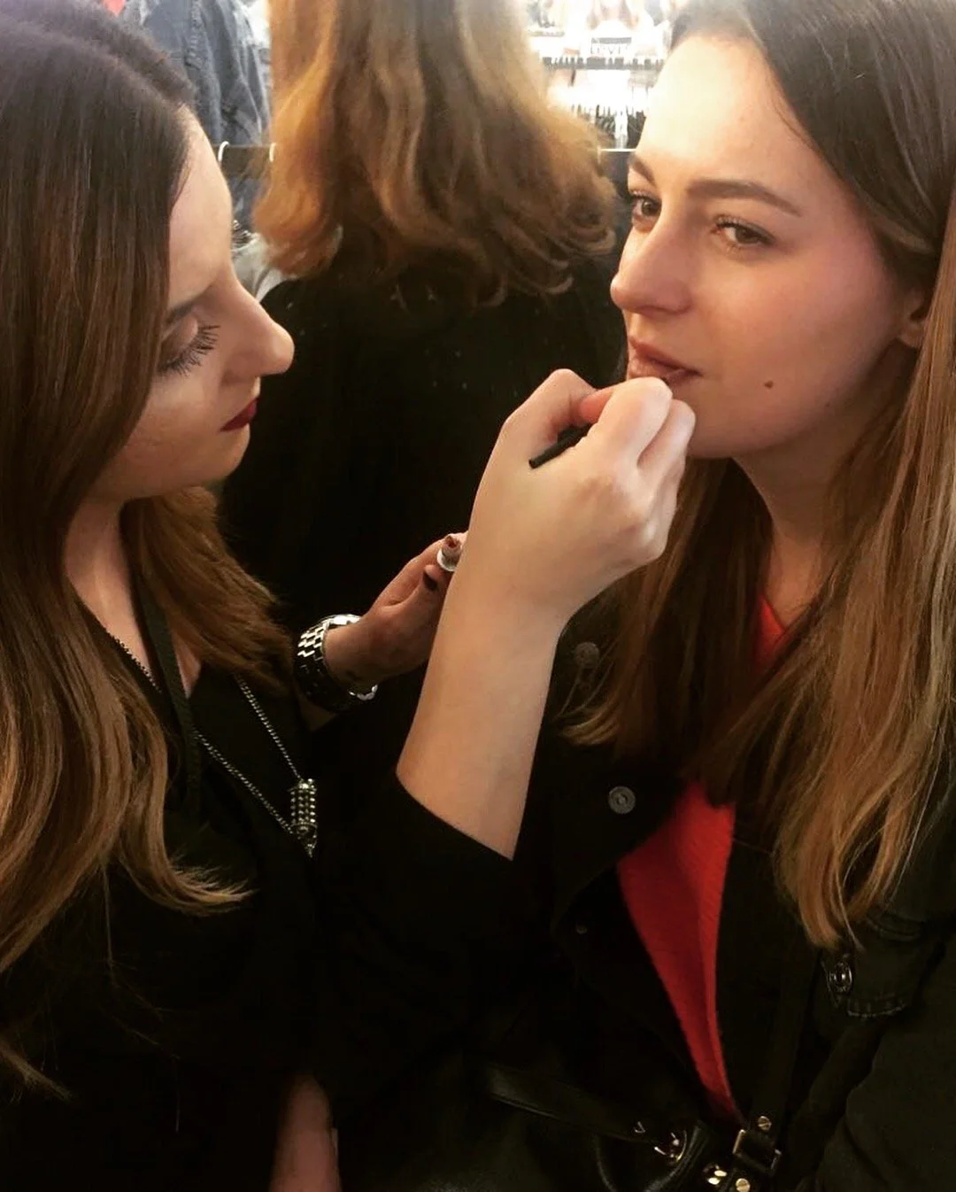 Eine Frau macht einer anderen Frau Make-up im öffentlichen Raum.