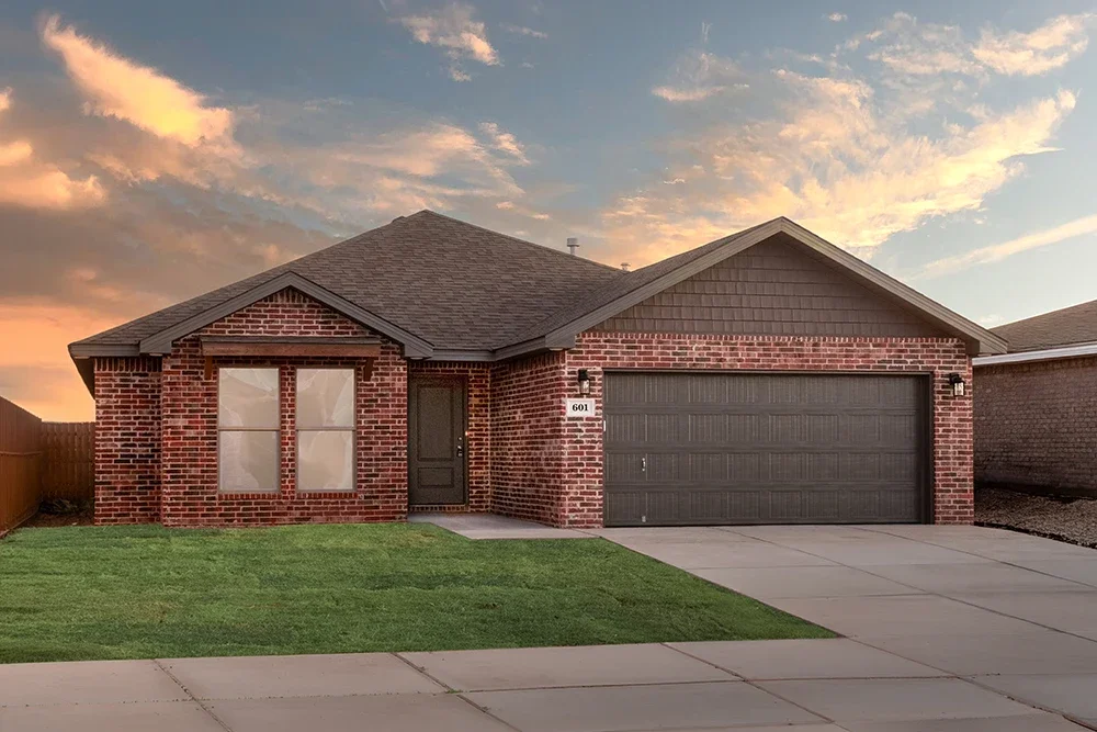 A new brick house with a dark garage door, two front windows, a front door, a well-maintained lawn, and a concrete driveway at sunset.