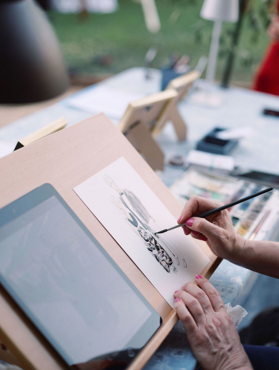 iPad on a drawing table with a portrait next to it