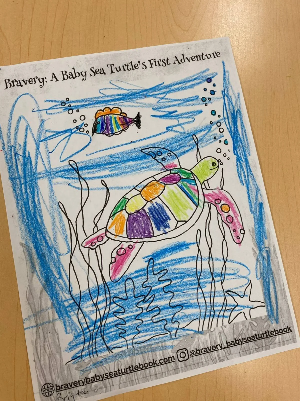 Child's colorful drawing of a sea turtle swimming underwater with seaweed, with a small fish in the background, titled 'Bravery: A Baby Sea Turtle's First Adventure'.