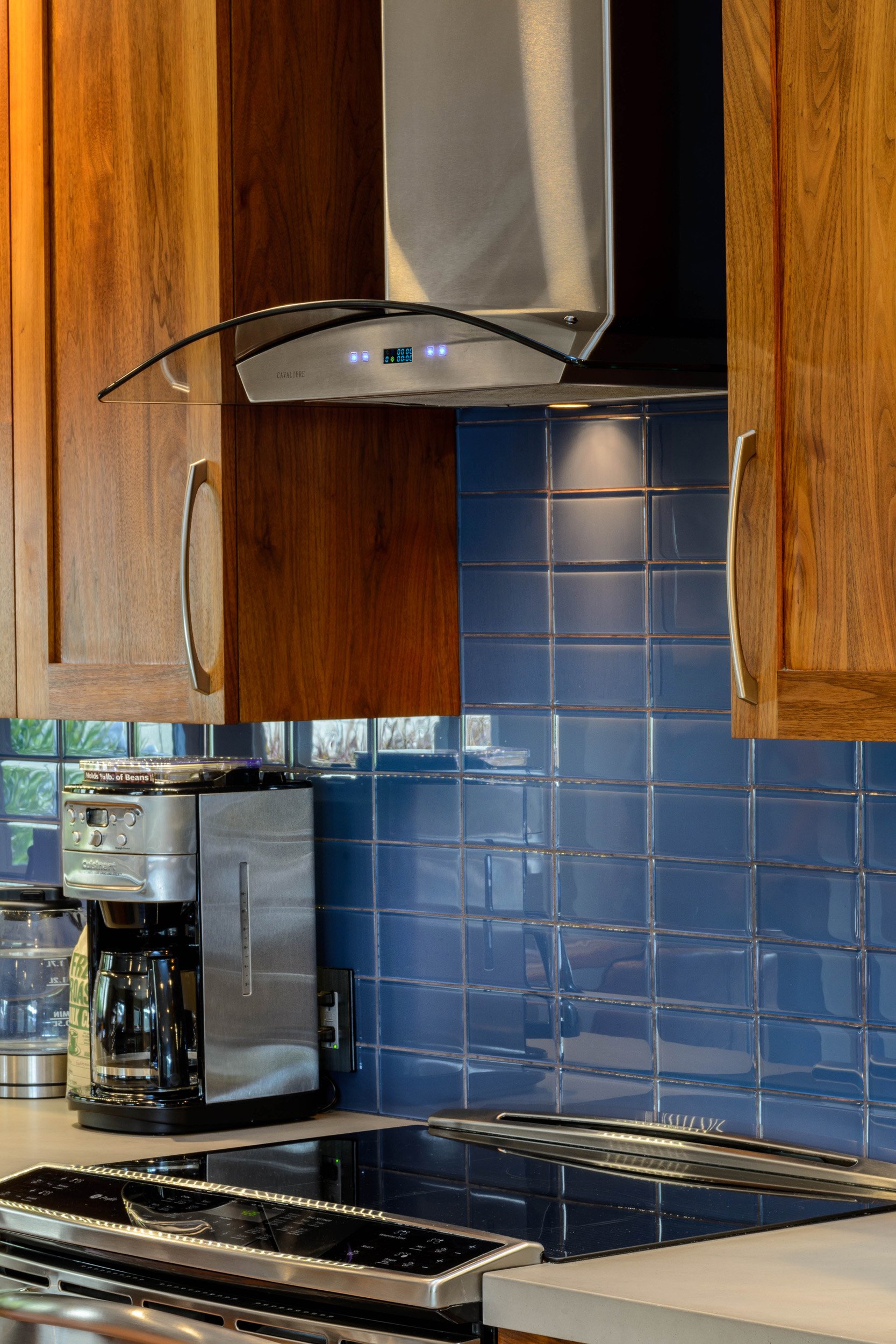 Warm-Contemporary-Kitchen-Blue-Glass-Backsplash-Hood-Range.jpg