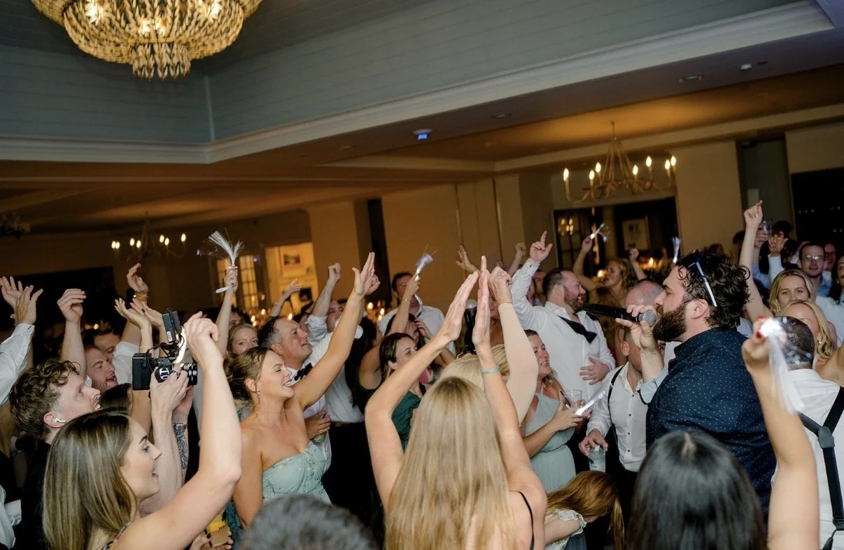 Wedding guests dancing with hands up as the Keys and Company Events singer performs on the dance floor