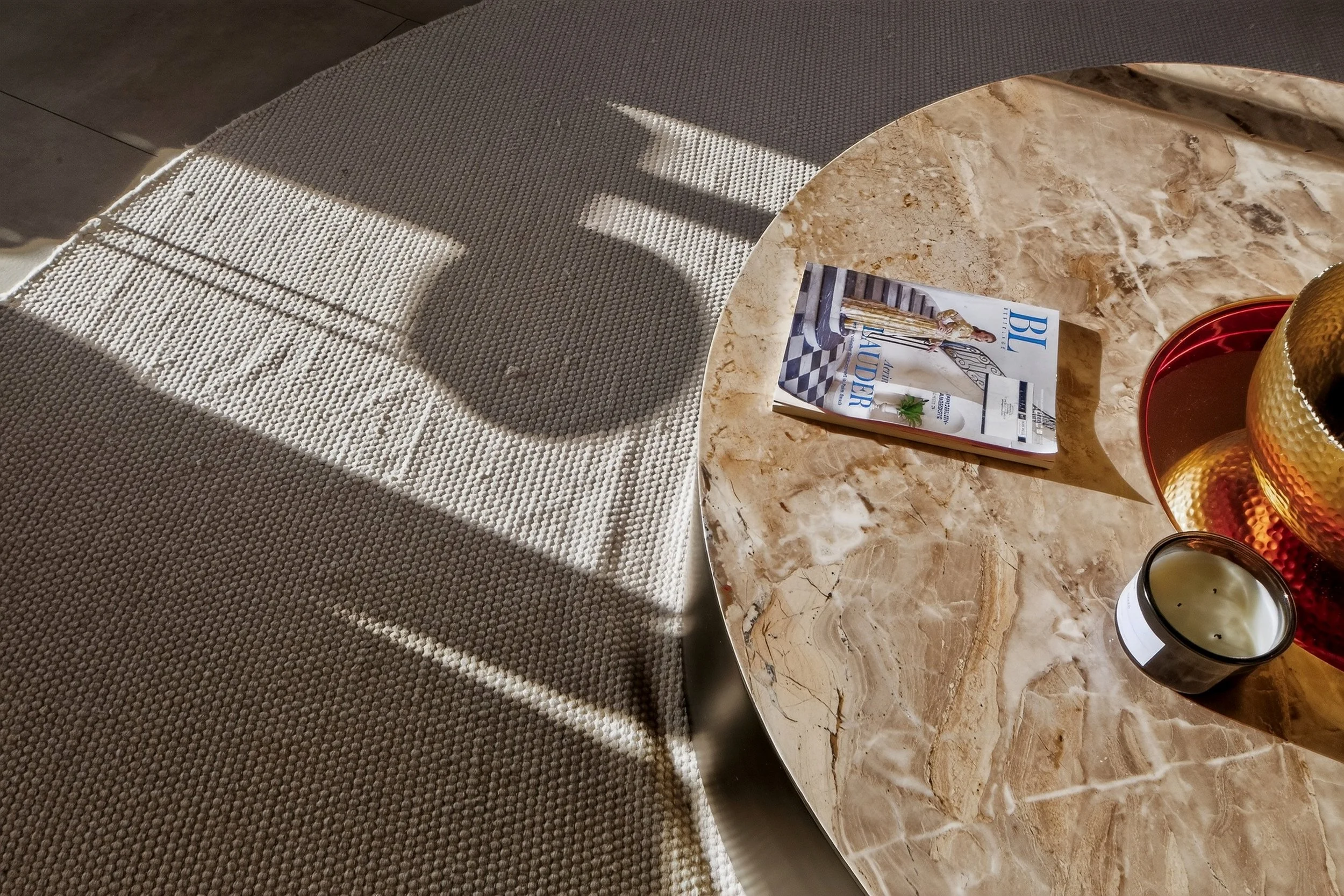 Detailaufnahme eines modernen Wohnzimmers mit Naturstein-Couchtisch, stilvoller Dekoration, natürlichem Tageslicht und hochwertigem Interior Design, professionell fotografiert für Immobilien- und Architekturfotografie in Deutschland.