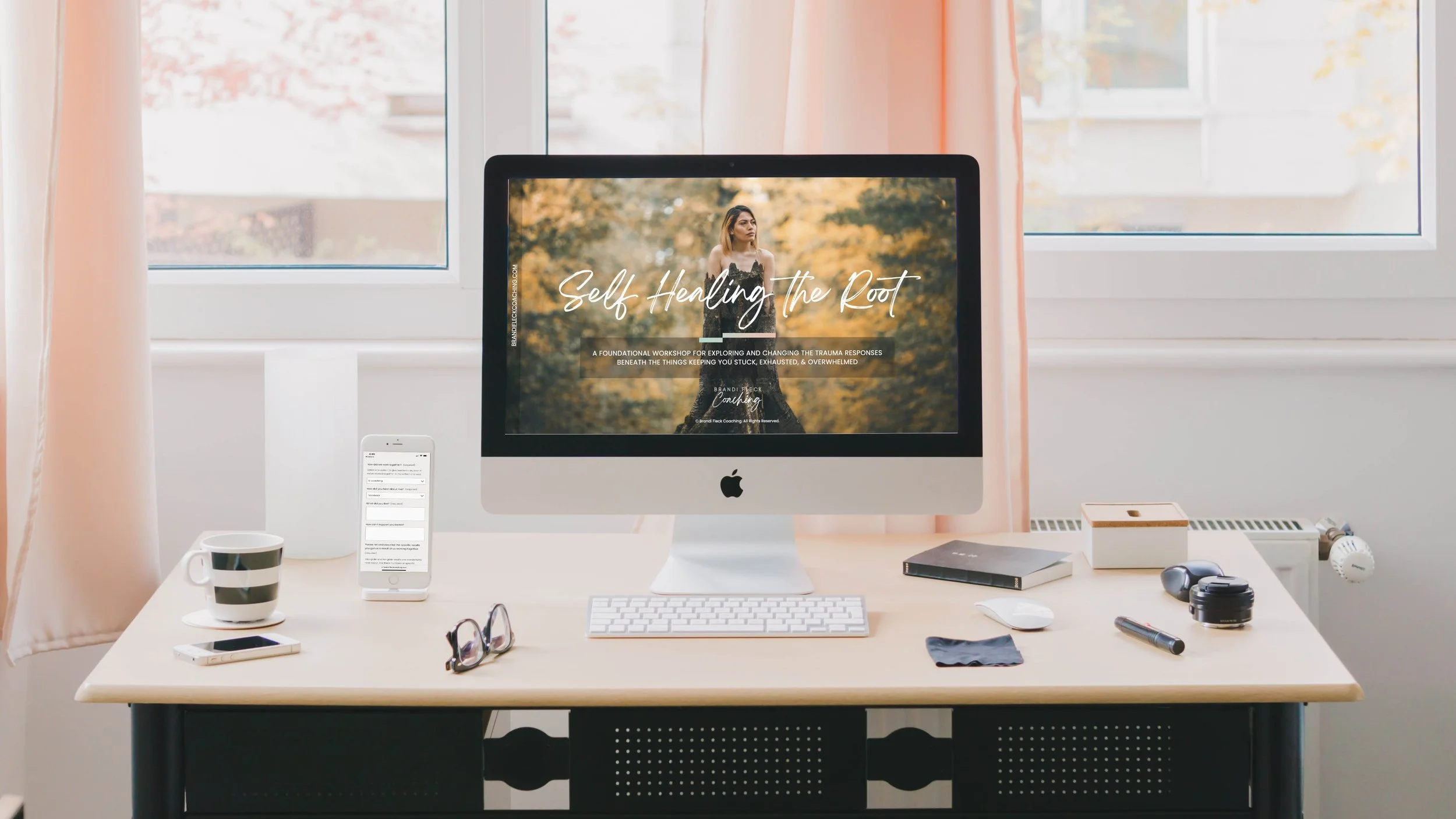 A computer on a desk in front of a window with peach curtains.