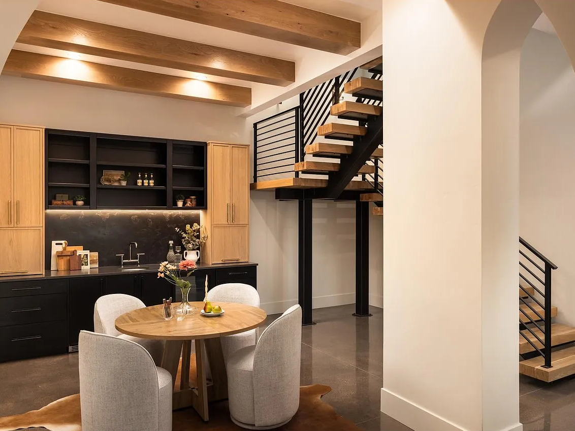 Two-tone bar cabinetry under white oak box beams.