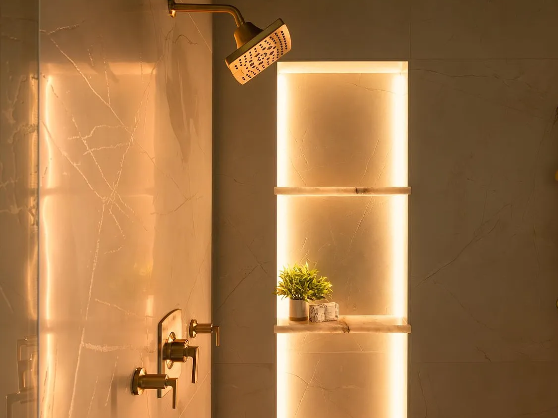 Lit niches float marble shelves against the stone.