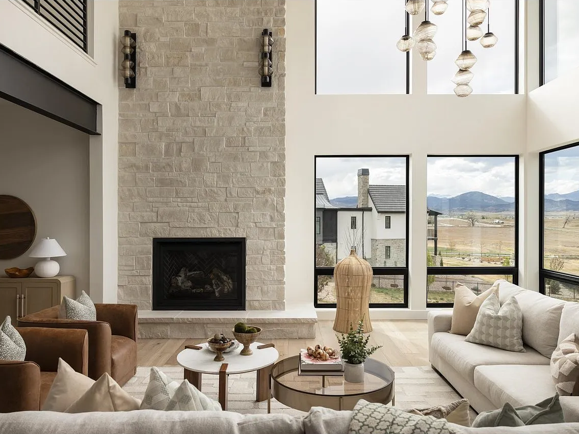 Mesa Mandrel sconces flank the limestone fireplace under a cascade of glass pendants.