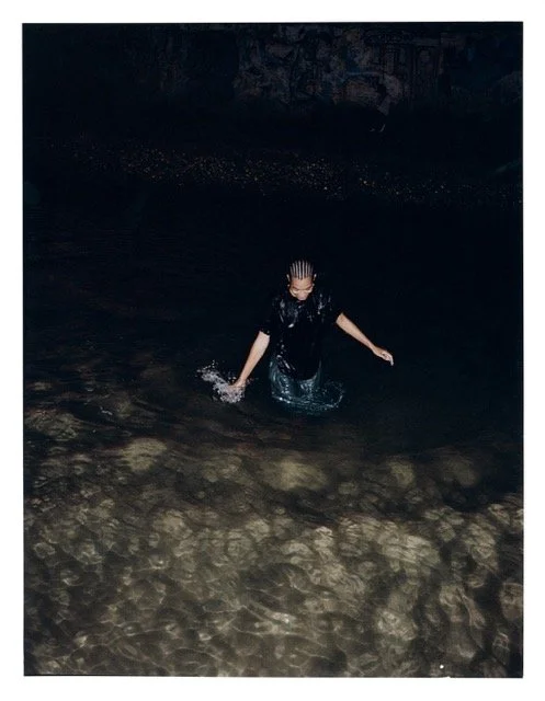 Person wading in a body of water inside a cave