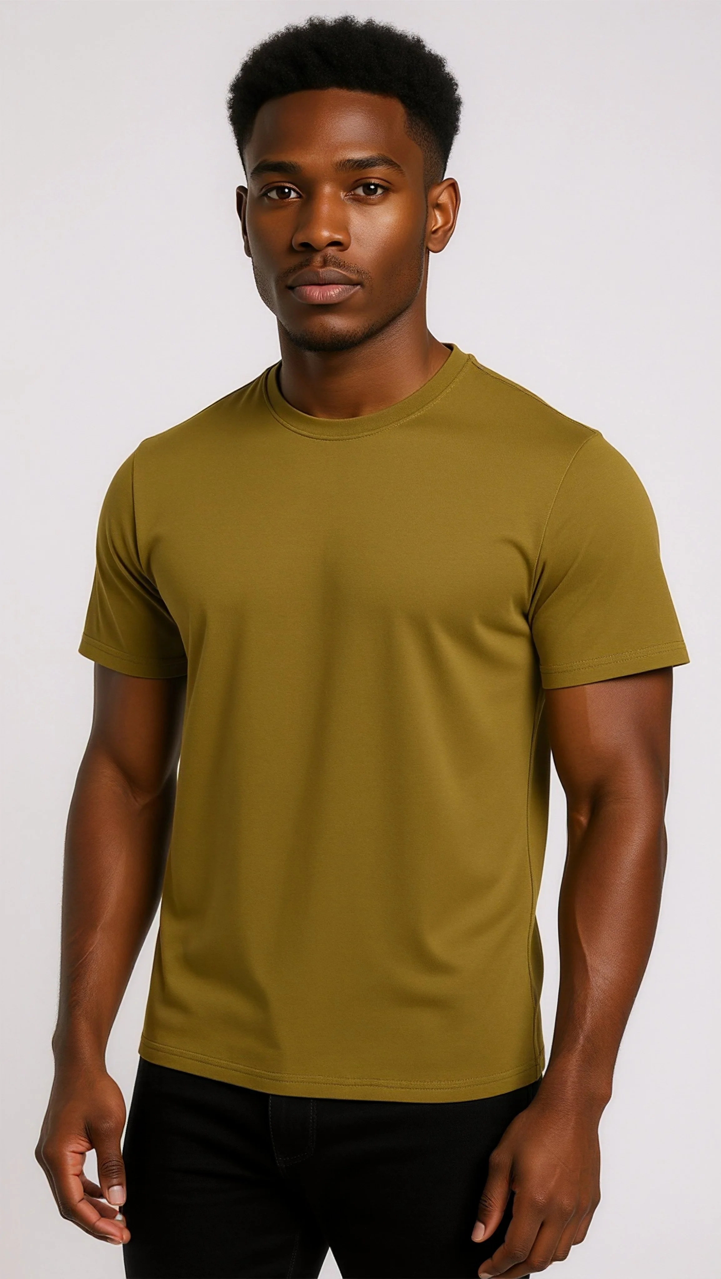 A young man with dark skin, short curly hair, wearing an olive green t-shirt and black pants, standing against a plain white background.