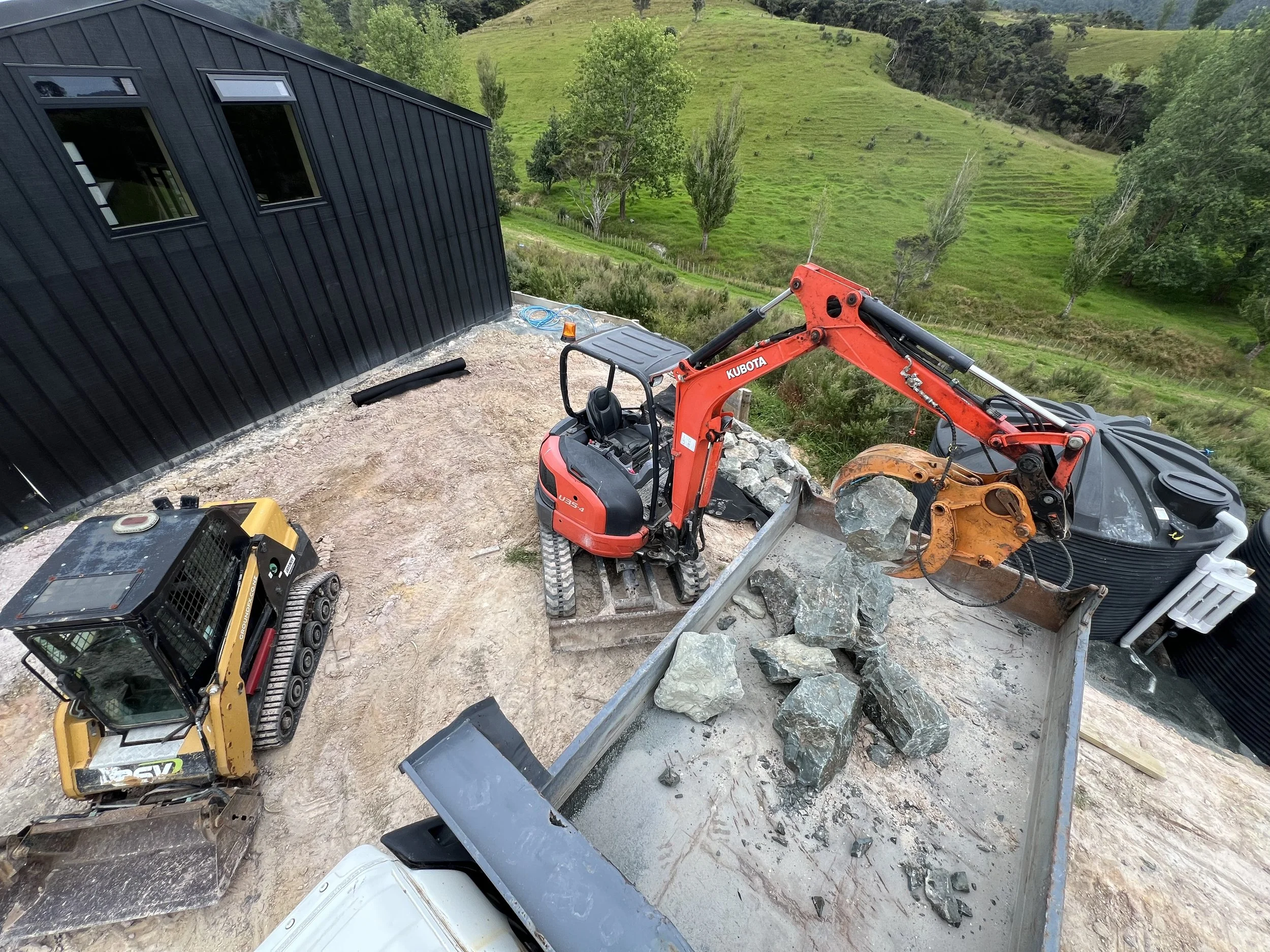 small scale earthworks, digger, skid steer, large rock, site works