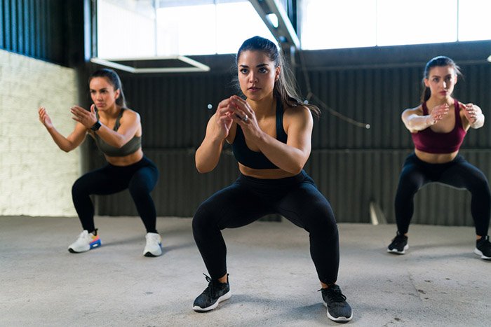 three women doing squat exercises