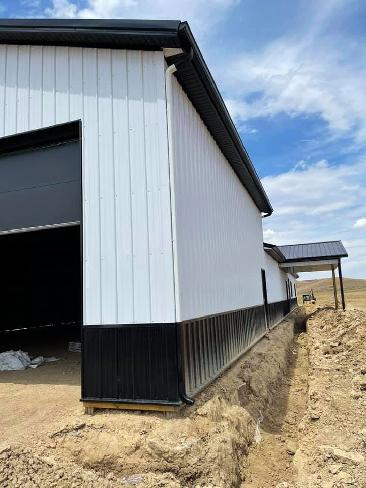 Gutters installed on a large white building by Vazquez Garage Doors and Gutters