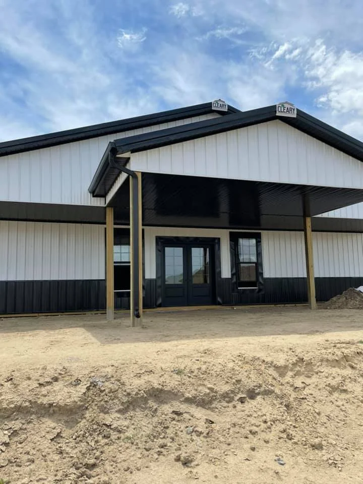 Large white and black building with black gutters installed by Vazquez Garage Doors and Gutters