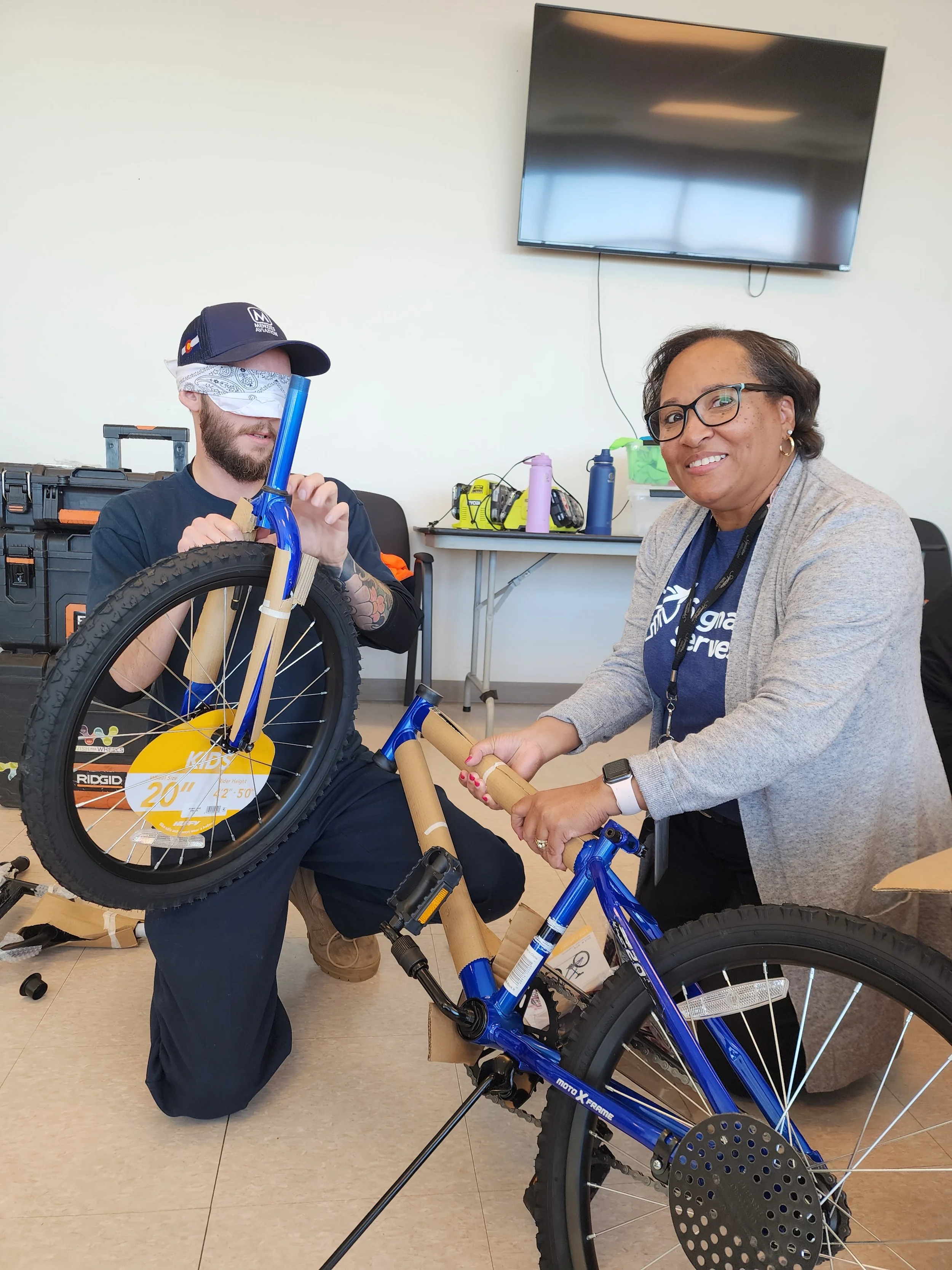 Employees working together to build a bicycle during a shared-purpose team-building activity