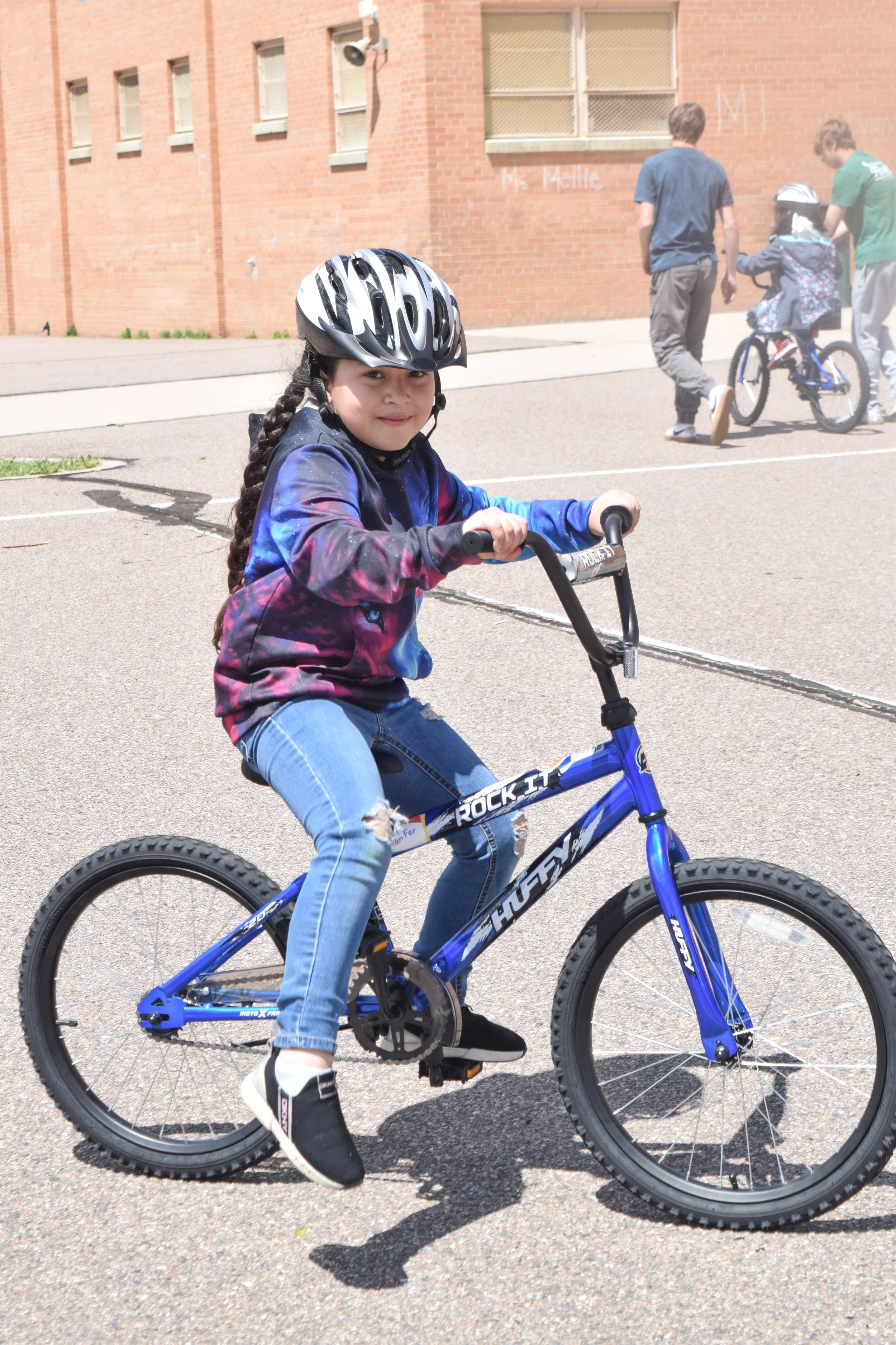 Child riding a bicycle received through a community Bike Build & Give event
