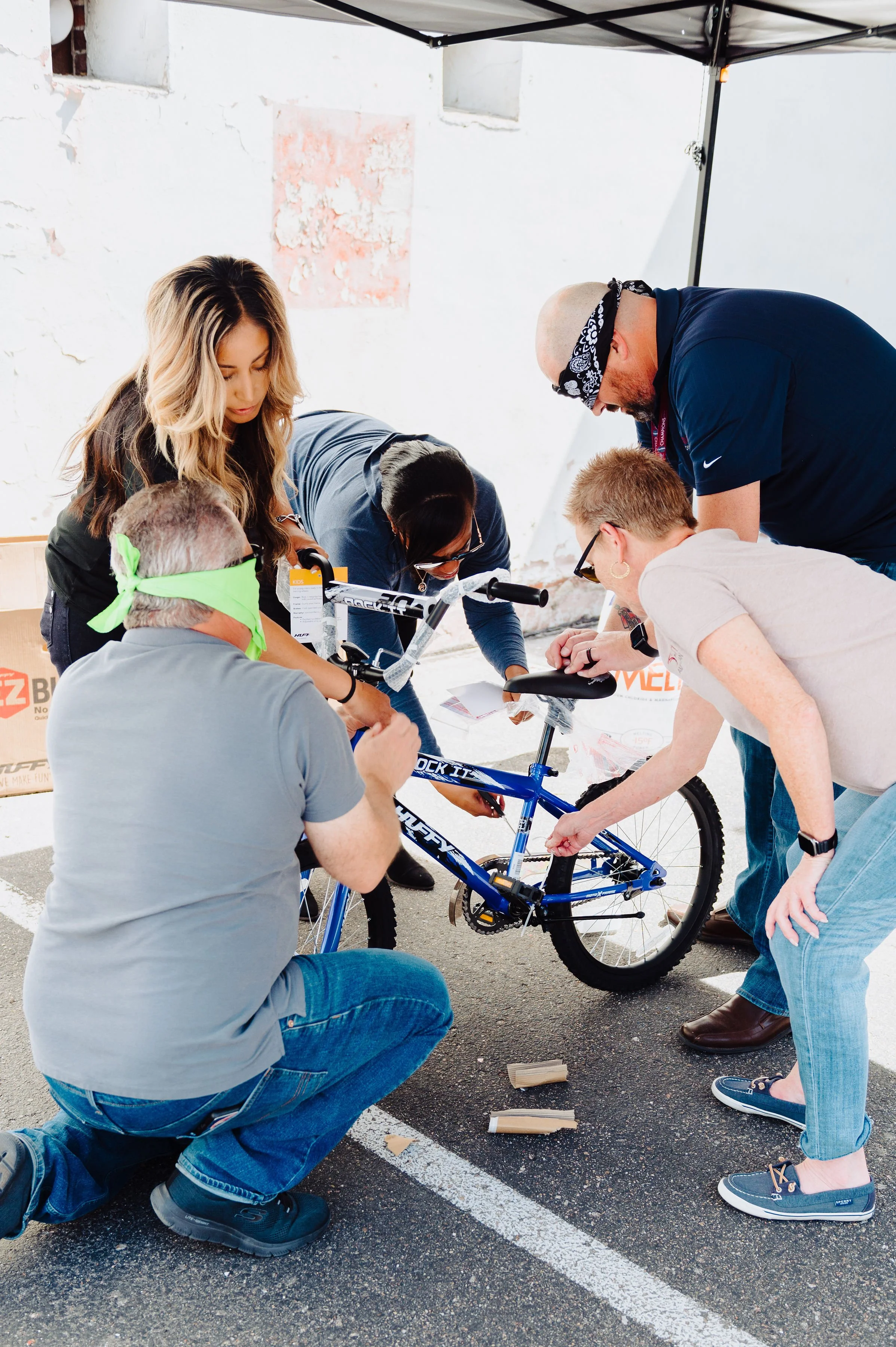 Employees working together to build a bicycle during a team-building Bike Build & Give event