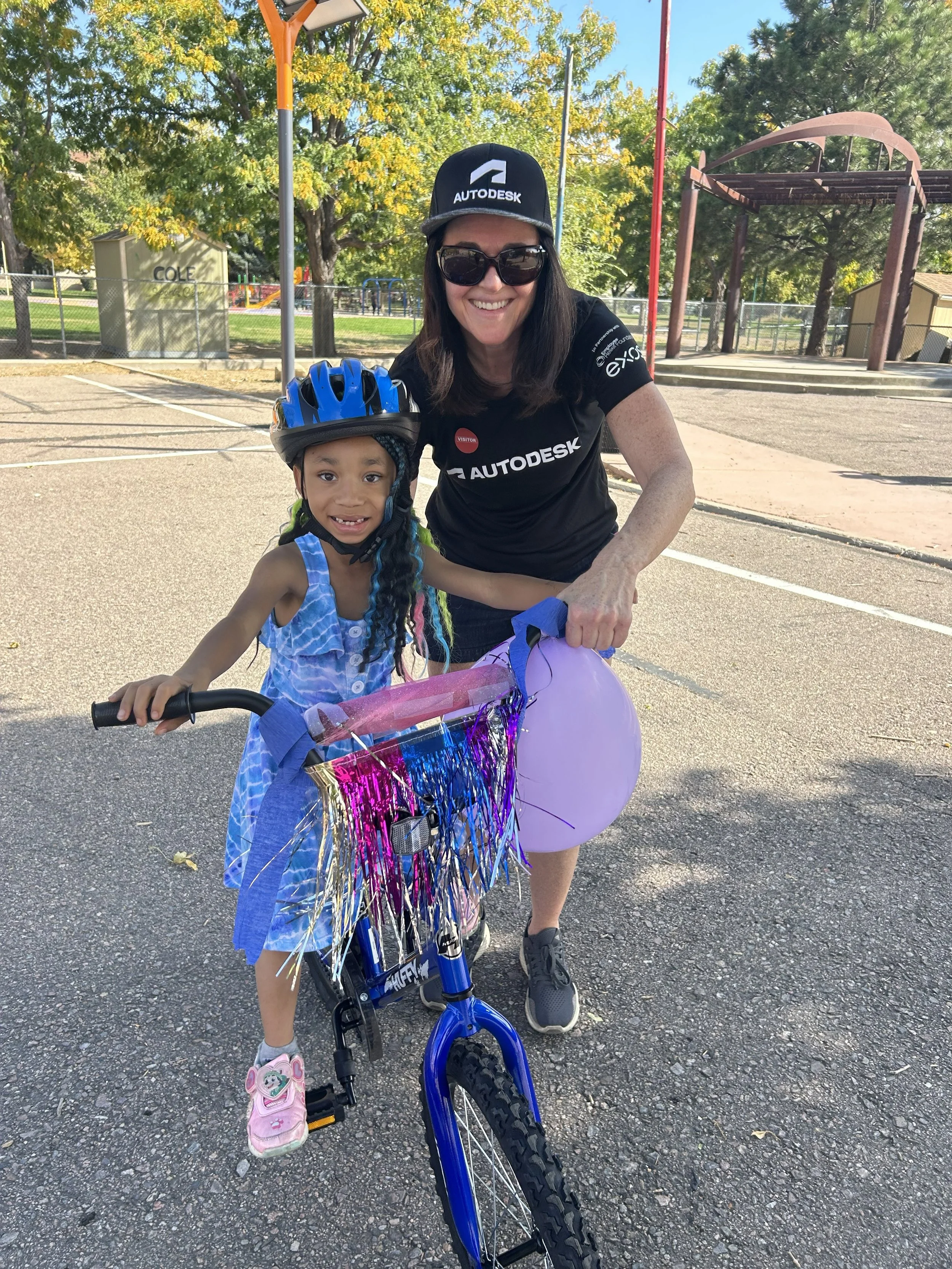Child with a bicycle and helmet alongside a volunteer at a community bike giveaway event