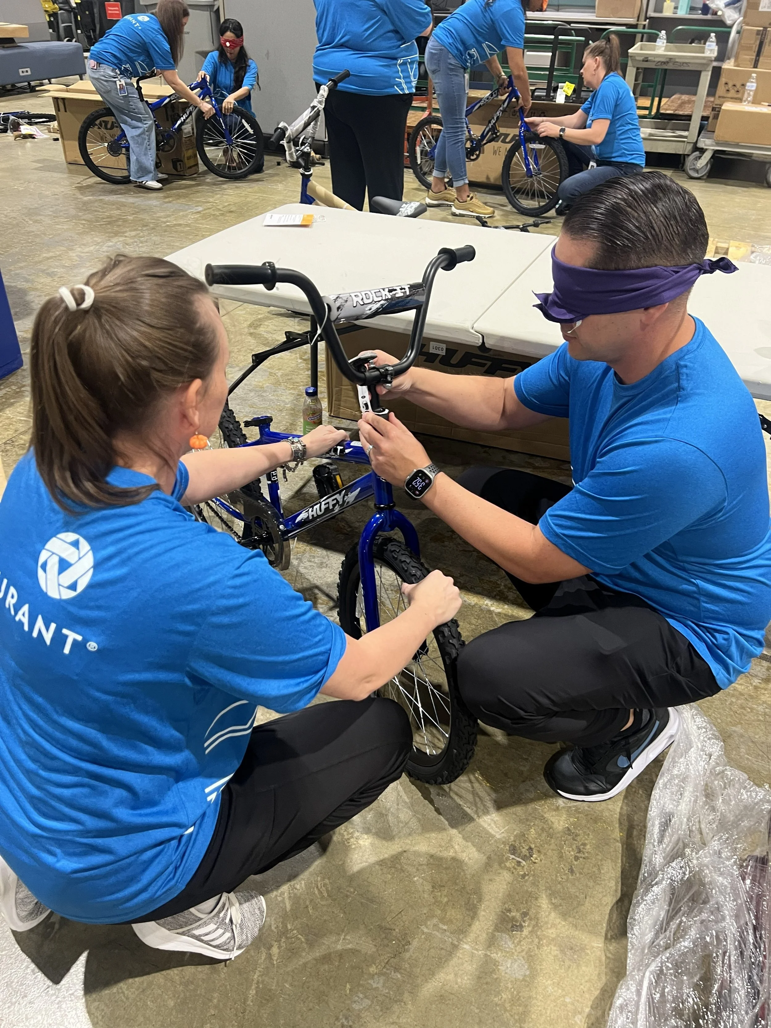 Employees working together to assemble bicycles during a team-building event