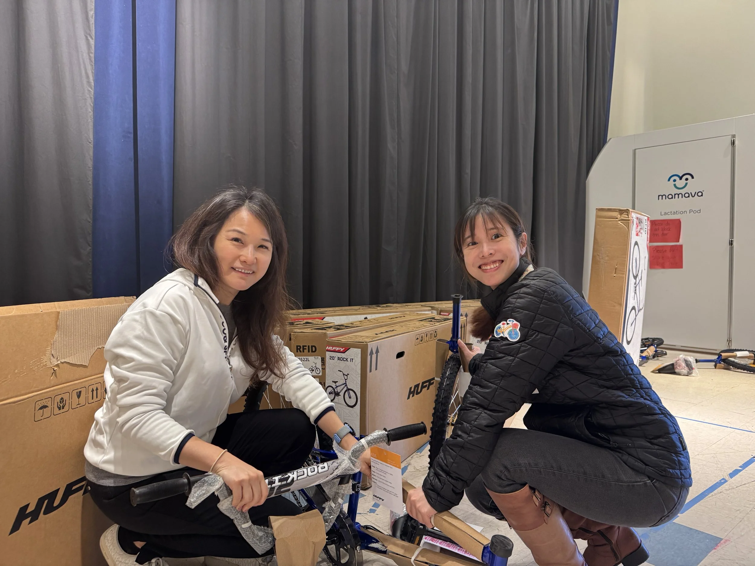 Employees collaborating to build a bike at a Wish for Wheels corporate team building event.