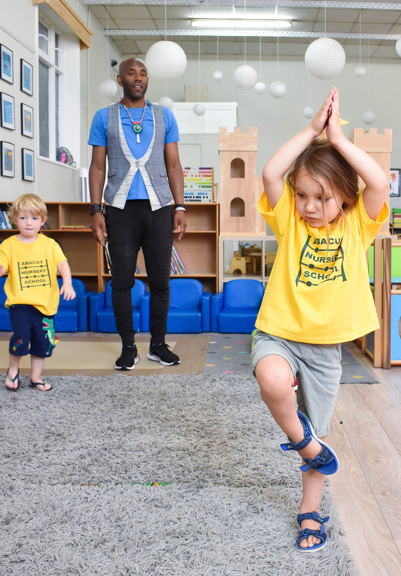 Nursery practitioner comforting a young child in a calm early years classroom