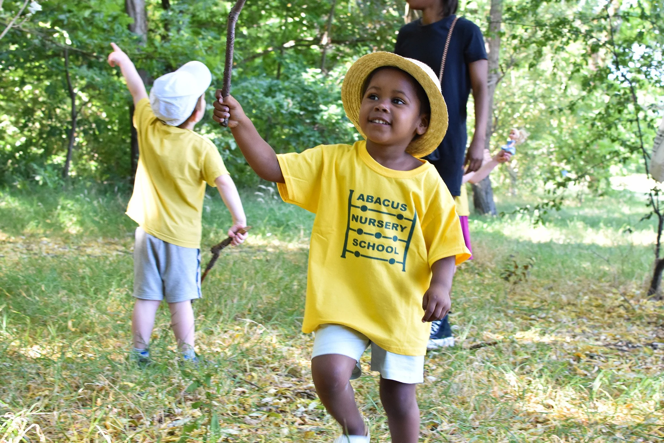 Children playing and exploring outdoors during forest school at Abacus Nursery School