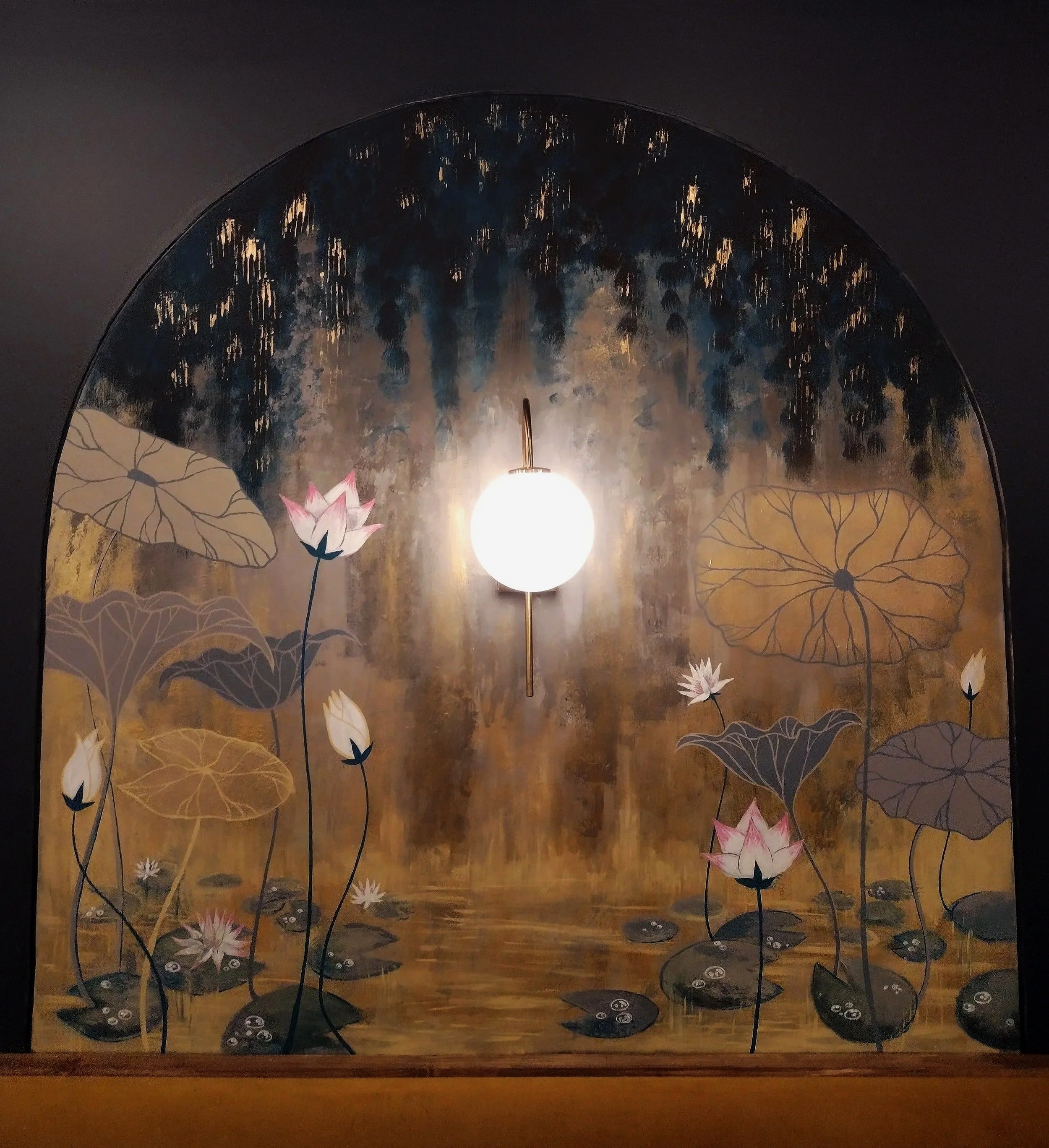 Wall mural of lotus flowers and leaves with a central glowing light fixture in an arched frame.