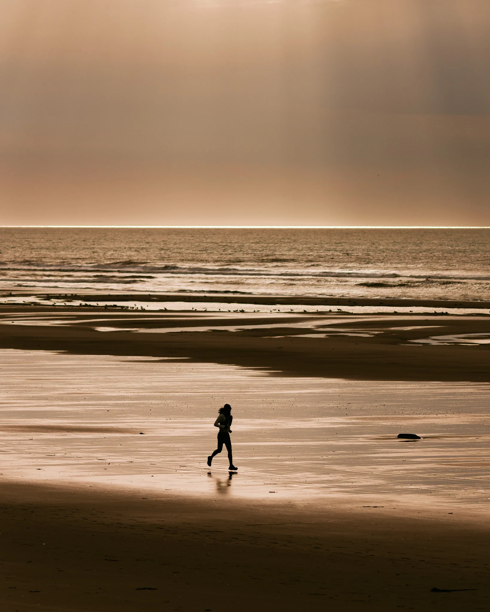 Photographie de Louis Derrien en train de courir sur une plage en Normandie. Il a couru des milliers de kilomètres pour mettre la lumière sur les troubles psy après la mort de son frère Simon.