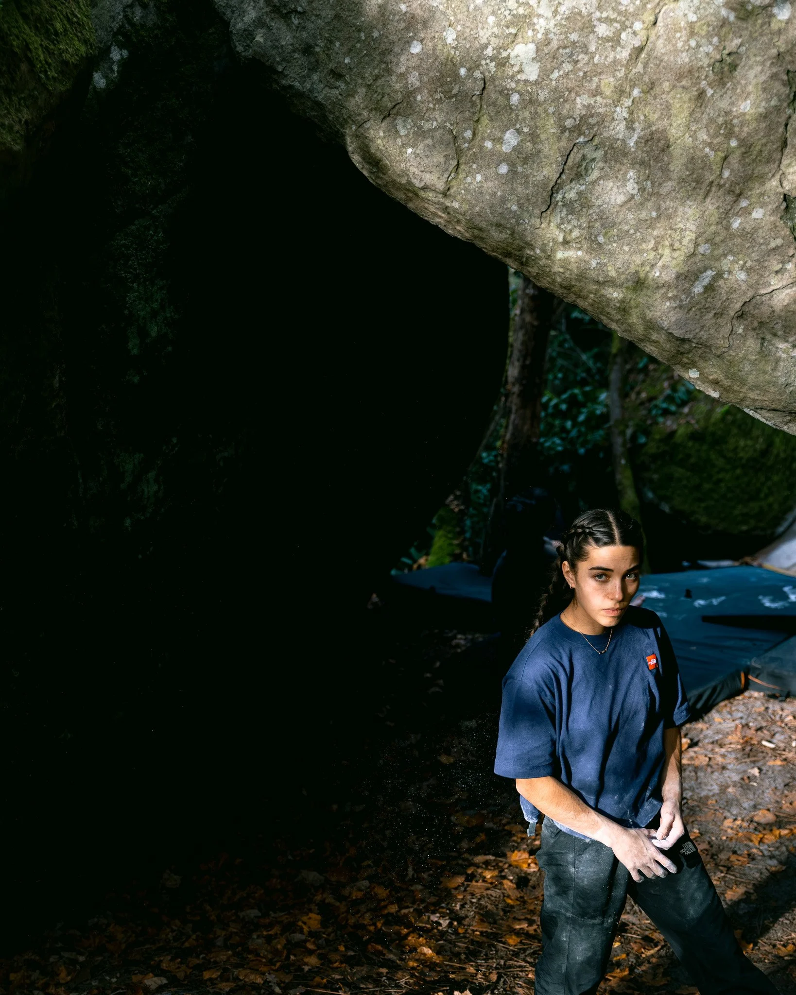 Une photographie de la grimpeuse franco-américaine Brooke Raboutou dans la forêt de Fontainebleau. Elle travaille ici un bloc de cotation élevée, la veille du contest Team Boulder Arena organisé par Climbing District.