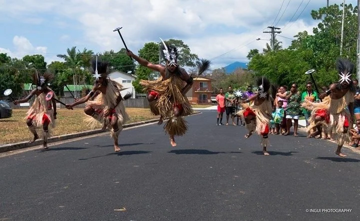 An image of Boigu Island Dance Team performing at a Traditional Shaving party in Cairns 2019 There are 5 Island warriors performing a heart pumping dance, they are wearing traditional island warrior dress with traditional weapons.