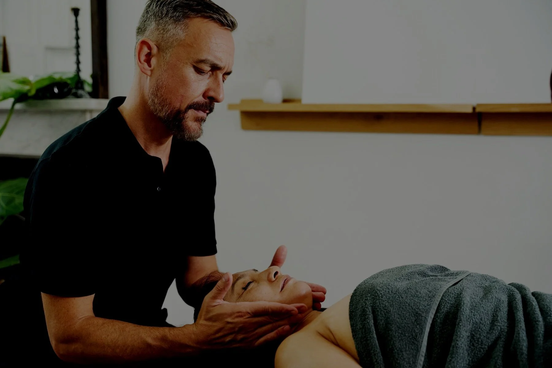 Woman lying on her back having neck and shoulder massage