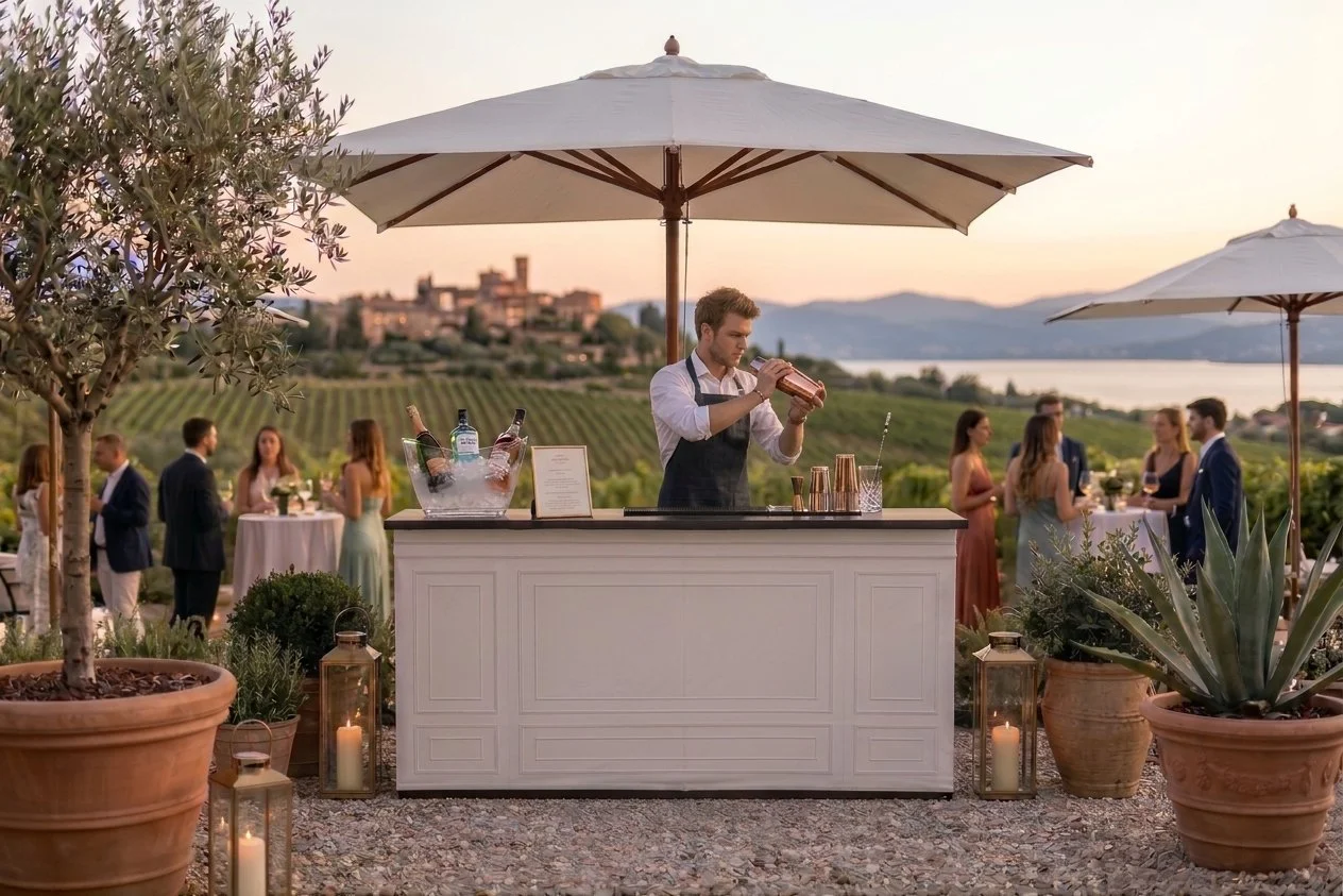 Elegante Outdoor-Cocktailbar mit Barkeeper unter Sonnenschirmen inmitten eines Weinbergs mit Seeblick