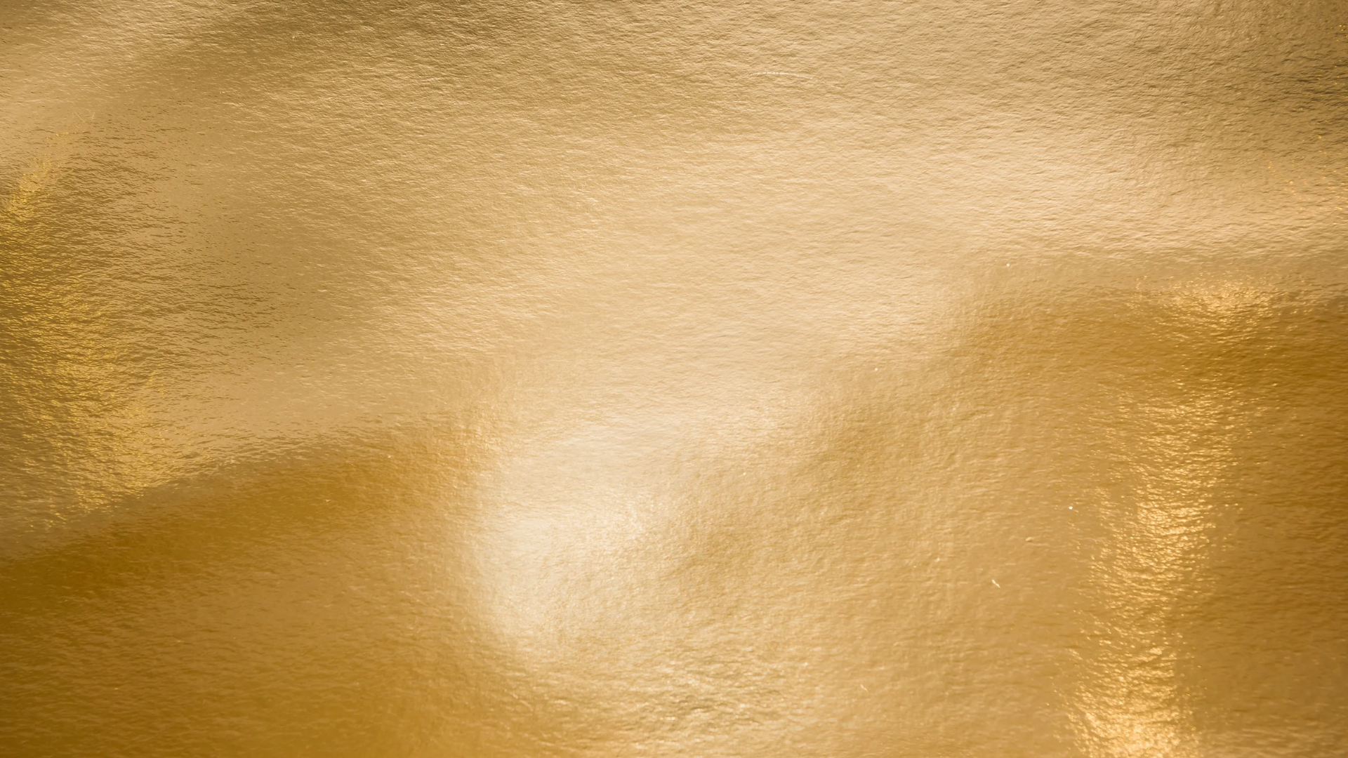 Close-up of a gold metallic surface with a textured, shiny finish.