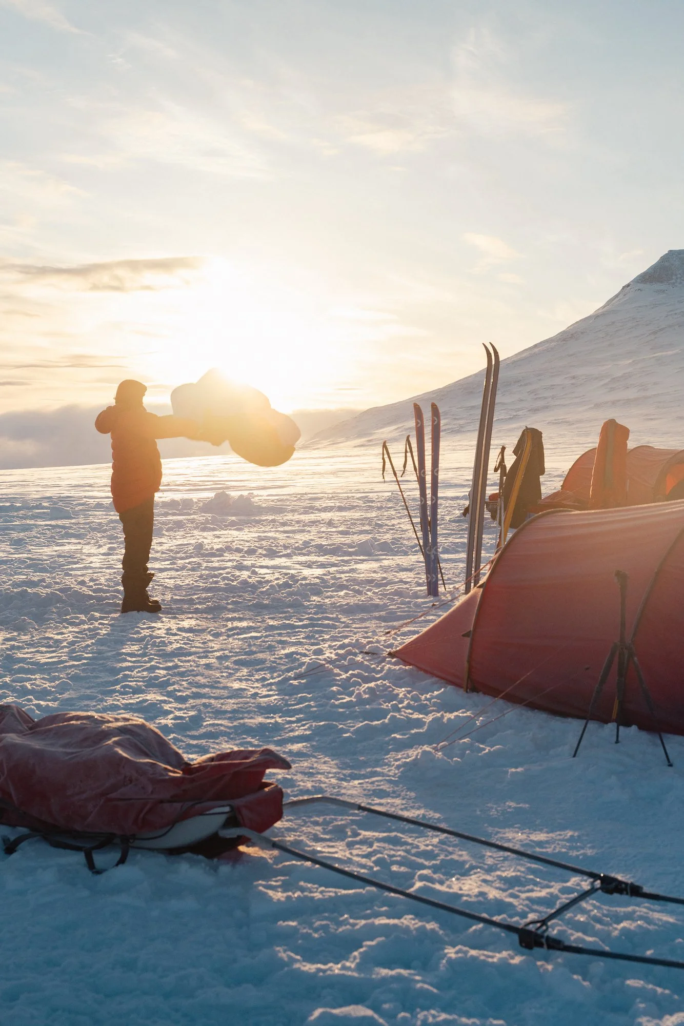 Teltta tunturissa ja ihminen joka tuulettaa makuupussia