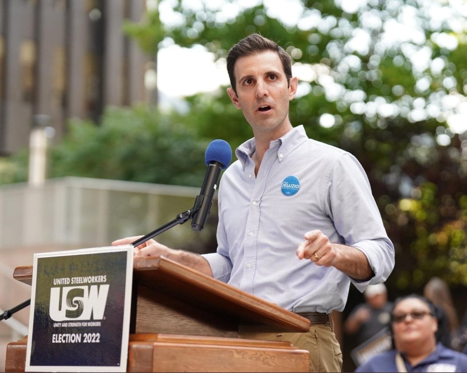 Chris DeLuzio speaks behind a brown podium with a sign that reads "United Steelworkers USW Election 2022."