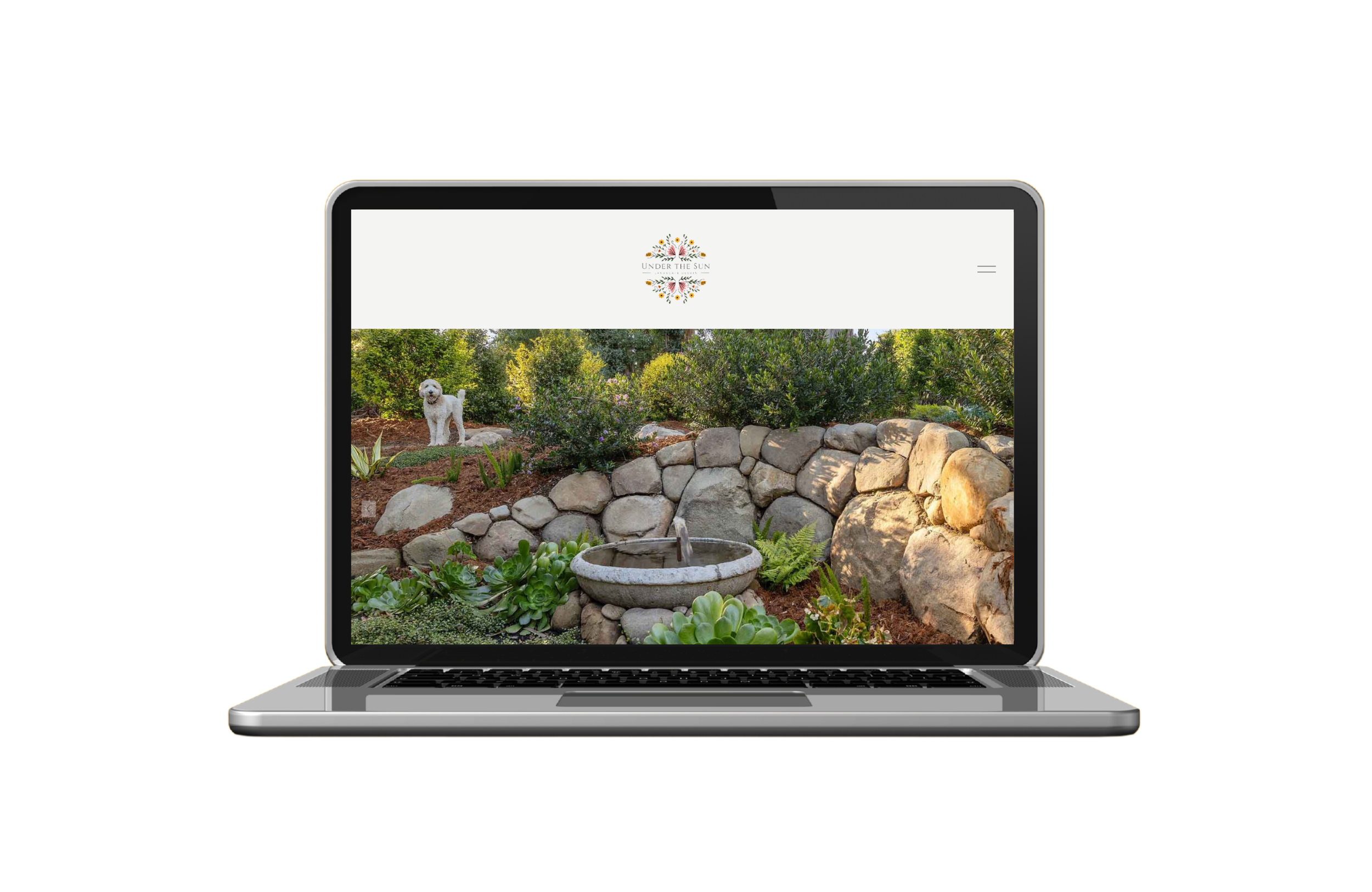 Laptop displaying a garden scene with a stone fountain, rocks, and a dog in the background.