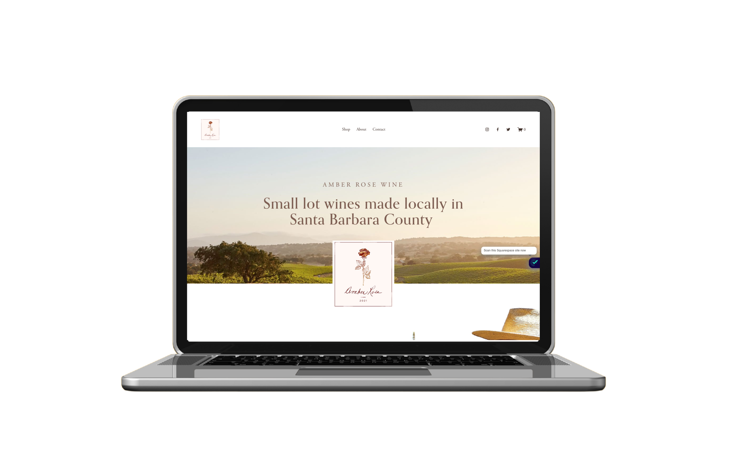 Laptop displaying a website for Amber Rose Wine, featuring a scenic vineyard landscape and the text 'Small lot wines made locally in Santa Barbara County'.