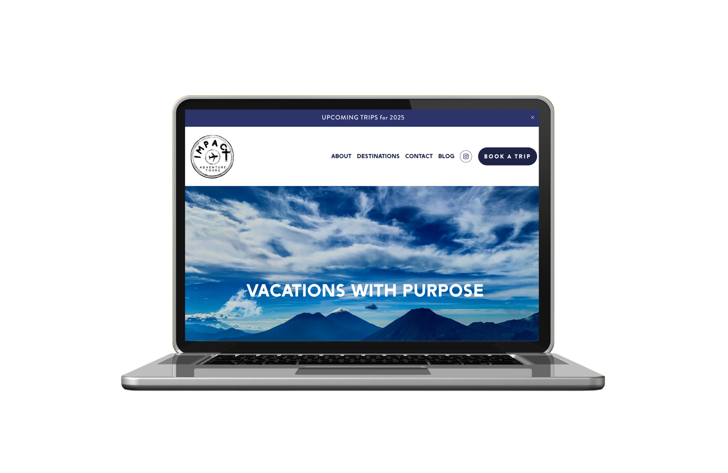 Laptop displaying a travel agency website with a scenic mountain and sky background and the text 'Vacations with Purpose'