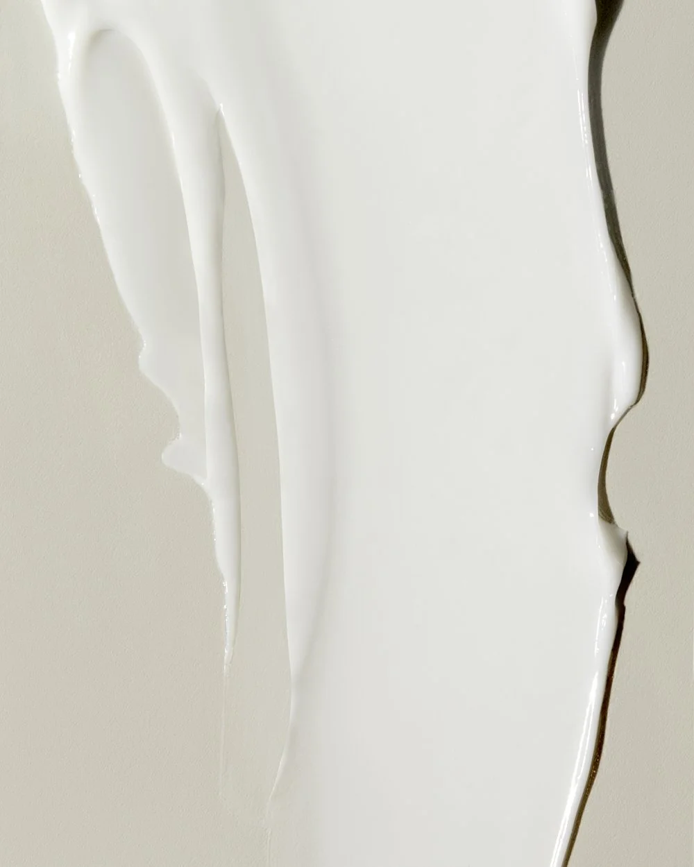 Close-up texture shot of pale cream curving over a dark green edge, by Adrianna Favero.