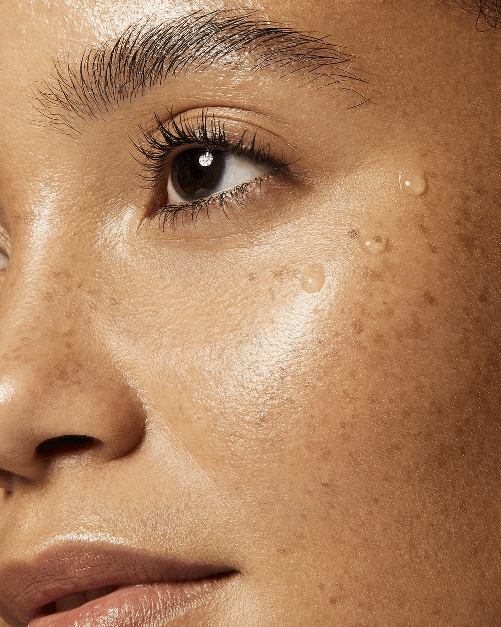 Macro clean beauty image by Adrianna Favero, NYC-based beauty photographer and director. Showcasing a cleansing and moisturizing routine on a freckled model’s glowing skin—perfect for skincare campaigns, natural beauty branding, and editorial feature