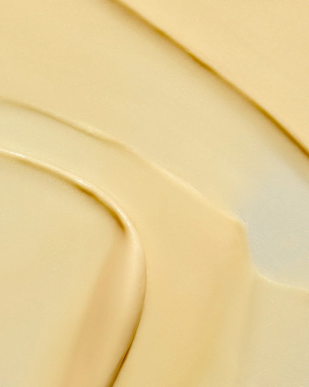 Close-up texture shot of golden cream swirled in a soft wave, by Adrianna Favero.