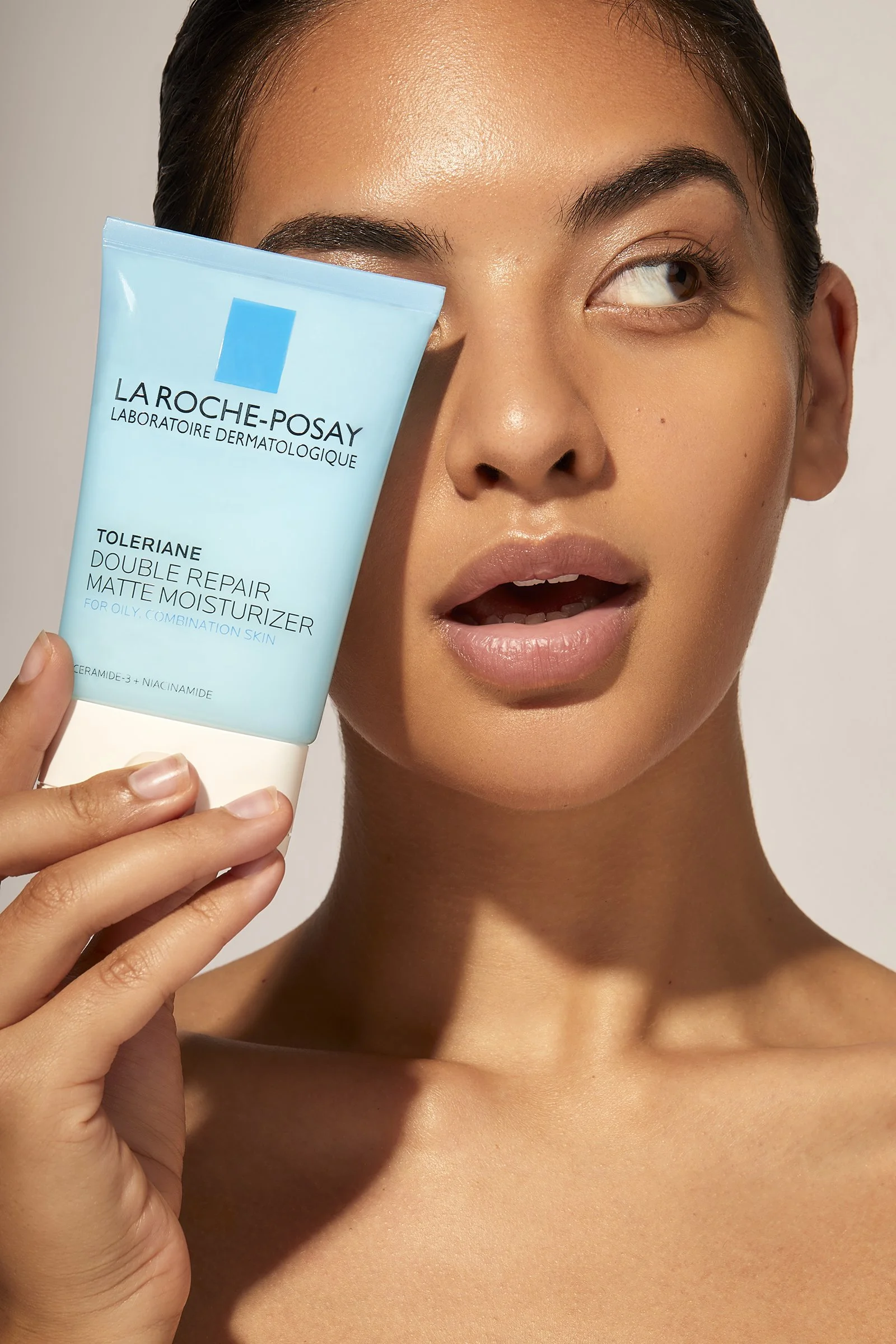 Person holding La Roche-Posay Toleriane Double Repair Matte Moisturizer near their face.